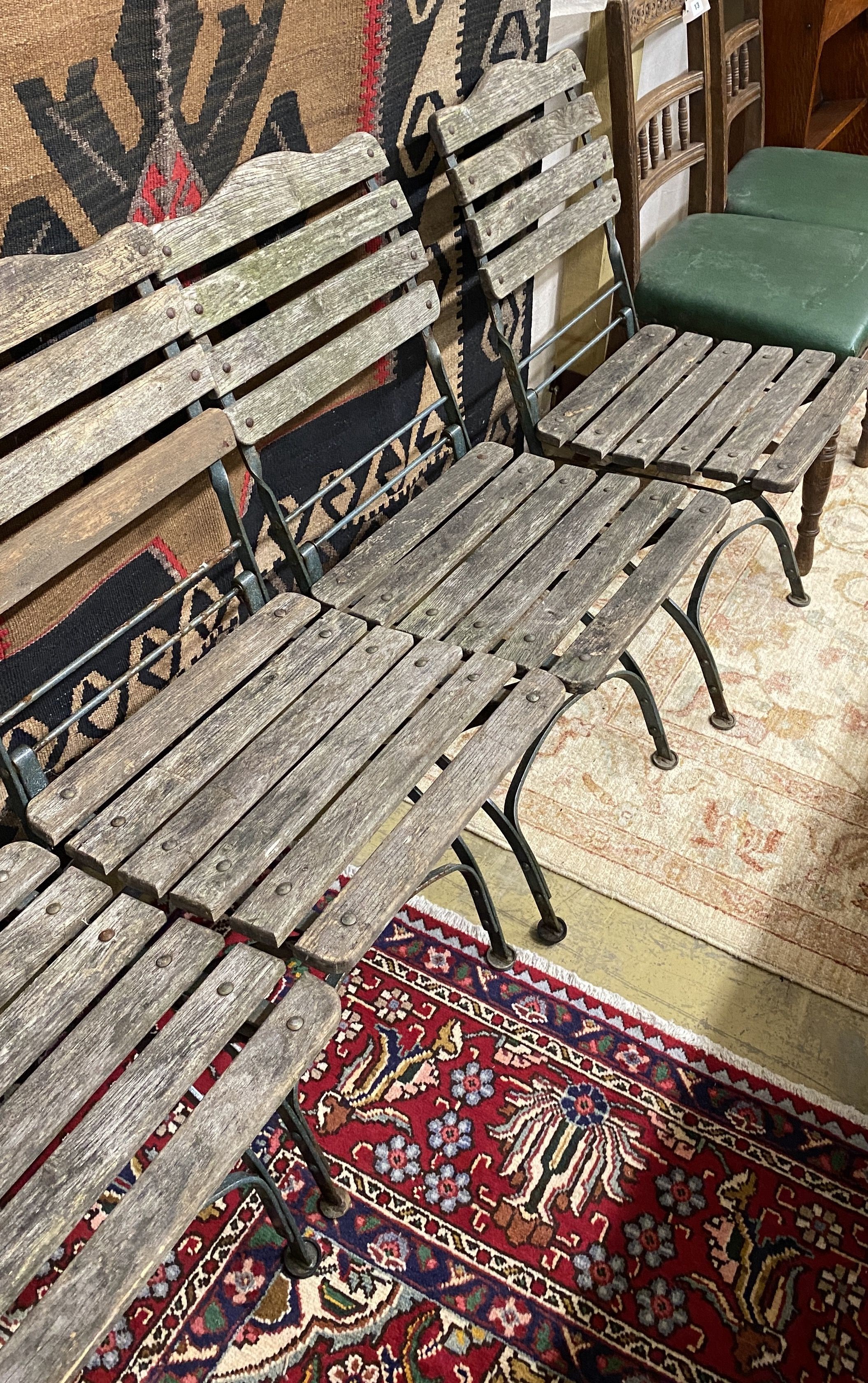 A set of four wrought iron slatted wood garden chairs